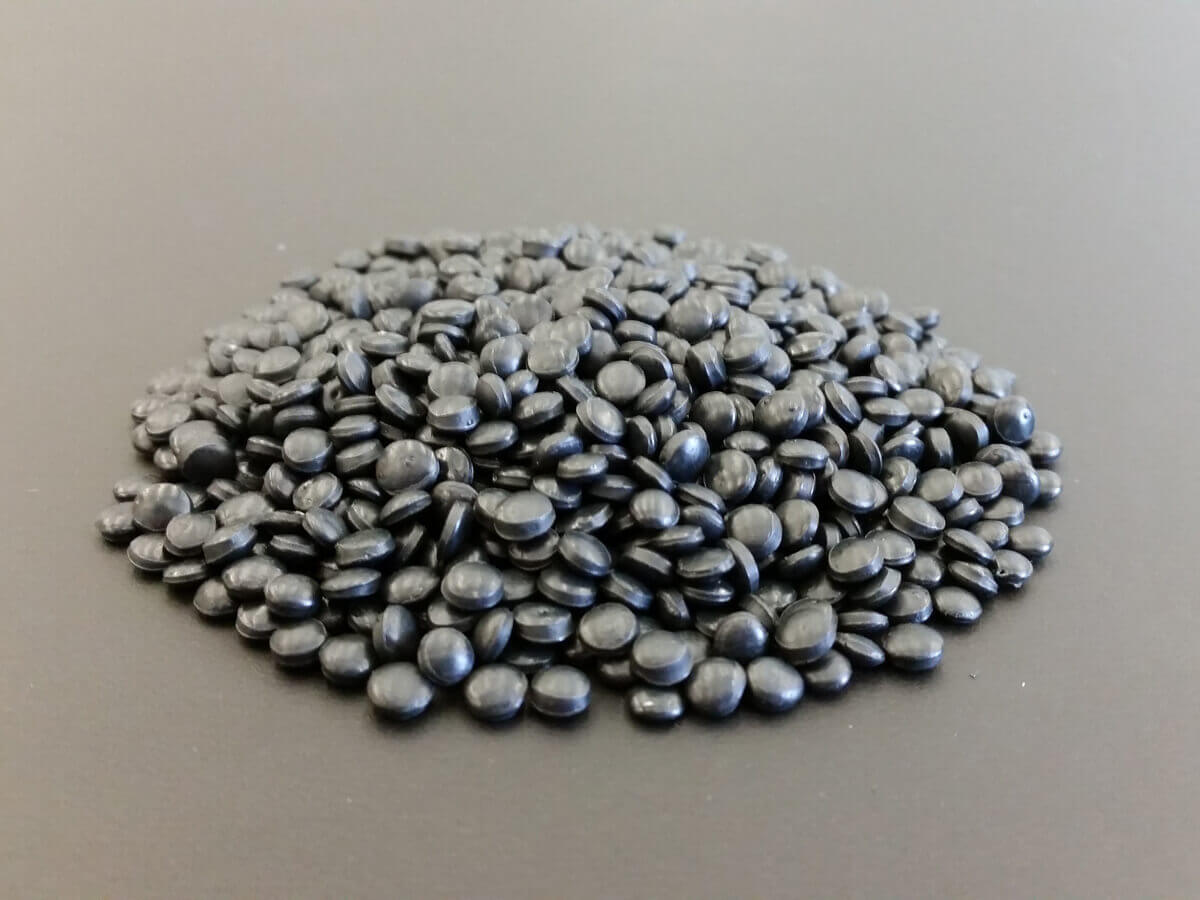 Sorte plastik piller som bruges til bæredygtig produktion - PaveSystems